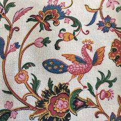 an embroidered fabric with colorful flowers and birds on it's back side, showing the design