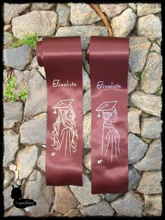 two red ribbons with drawings on them are hanging from a stone wall in front of some rocks