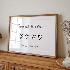 a framed print with the words grandchilden and hearts in black ink on a wooden shelf