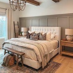 a bedroom with a large bed and chandelier hanging from it's ceiling