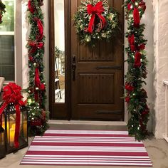 the front door is decorated for christmas with wreaths and lights