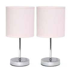 a pair of pink lamps sitting next to each other on top of a white table