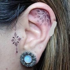 a close up of a person's ear with tattoos on it