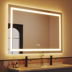 a bathroom sink with a large lighted mirror above it