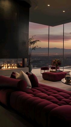 a living room filled with furniture and a fire place next to a large window overlooking the city