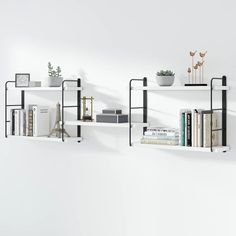 three white shelves with books and plants on them