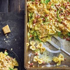 a pan filled with pasta and vegetables on top of a table