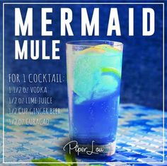 a blue cocktail in a tall glass sitting on top of a table with the words mermaid mule