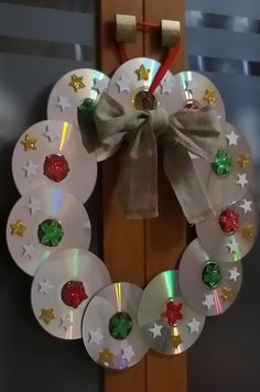 a christmas wreath made out of cds and ribbon