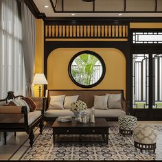 a living room filled with furniture and a large round mirror on the wall above it