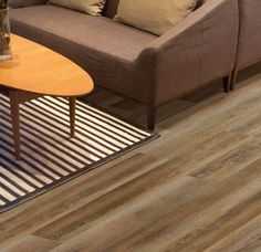 a living room filled with furniture and a wooden table on top of a hard wood floor