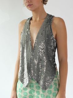 Vintage Y2K silver sequin vest from the Danish designer Rützou Closure: None Label: Rütou, Made in Denmark Materials: 100% Cotton Fully lined (Pants sold separately) Label Size EU 38, UK 12, US 8. Please check measurements. The measures have been taken with the item flattened out - double bust. Armpit to armpit bag 45 cm - 17,71 inches Length Back 42 cm - 16,54 inches Length front 59 cm - 23,23 inches   Condition: Very good vintage condition. A bit of yellowing along the linen by the neck. Two short lines of sequins are missing - see photo    M i n t : Pristine with no signs of wear- possibly deadstock. E x c e l l e n t : Signs of normal wear and age- no obvious flaws. V e r y g o o d : Noted minor flaws that may have been already repaired - very wearable. G o o d : Many noted minor flaws Sequin Vest, Armpit Bag, Lined Pants, Vest Outfits, Silver Sequin, Danish Design, Label Sizes, Womens Vest, See Photo