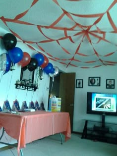 balloons and streamers are hanging from the ceiling in this party - like room, along with an entertainment center