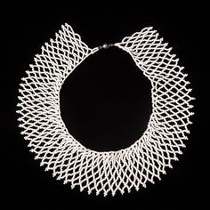 a white necklace on a black background