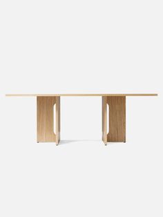 a wooden table with two legs and a white wall in the background, it is made out of wood