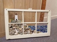 an old window is filled with rocks and shells