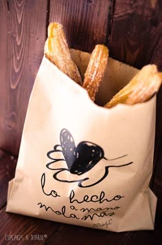 a bag filled with french fries sitting on top of a wooden table