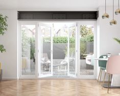 an open living room with sliding glass doors and wooden flooring, potted plant in the corner