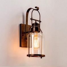 an old fashioned wall light with a glass jar hanging from it's back end