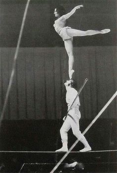 two men are performing acrobatic tricks in an old photo