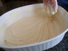 a person mixing batter in a white bowl