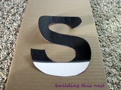 a cardboard box with the letter s cut out and sitting on top of carpeted floor