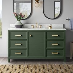 a bathroom with two mirrors and blue cabinets