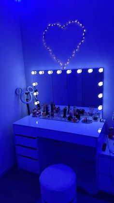 a vanity with blue lights and a heart shaped mirror