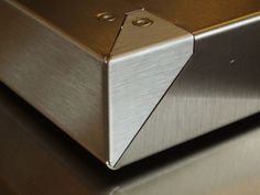 a close up of a metal object on a shiny surface with no one around it