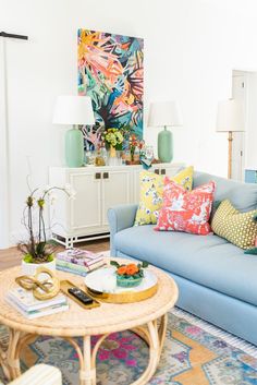 a living room with blue couches and colorful pillows on top of the rugs