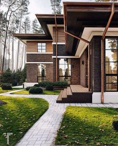 a modern house with landscaping and trees in the front yard