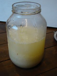 a jar filled with liquid sitting on top of a wooden table