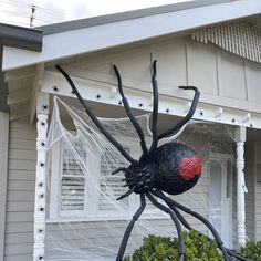 a large spider statue in front of a house