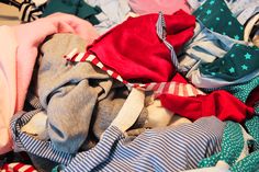 a pile of folded clothes sitting on top of a bed