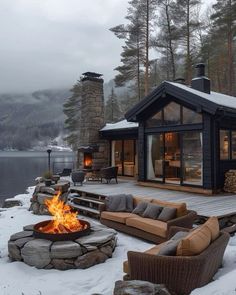 a fire pit sitting on top of a snow covered ground next to a wooden deck