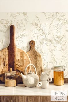 there is a wooden cutting board, tea pot and other items on the counter top