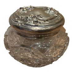 a glass jar with a metal lid sitting on top of a table