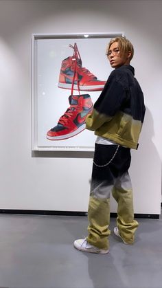 a man standing in front of a painting with shoes on it