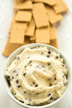 a bowl filled with ice cream next to crackers