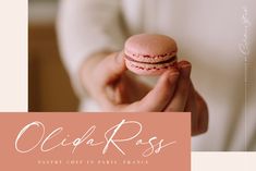 a person holding a pink macaron in their hand with the words ollija ross on it