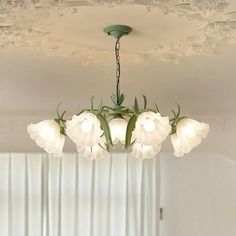 a chandelier with five lights hanging from it's ceiling in a living room