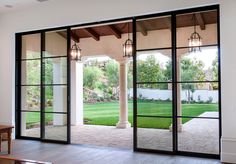 the inside of a house with glass doors and brick walkway leading to an outside patio