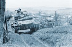 an old tank driving down a dirt road