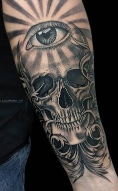 a man's arm with a skull and an eye on it