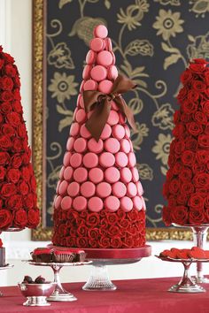 a table topped with lots of red roses covered in chocolates and pink macaroni shells