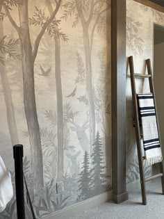 a room with a ladder, towel rack and wallpaper