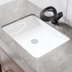 a white sink sitting on top of a counter next to a black faucet