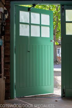 an open green door with glass panels on it