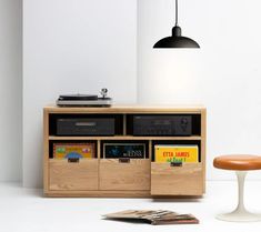 a record player and some books in a room with a stool next to the table