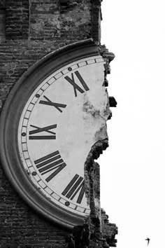 an old clock that has roman numerals on the side of a brick building